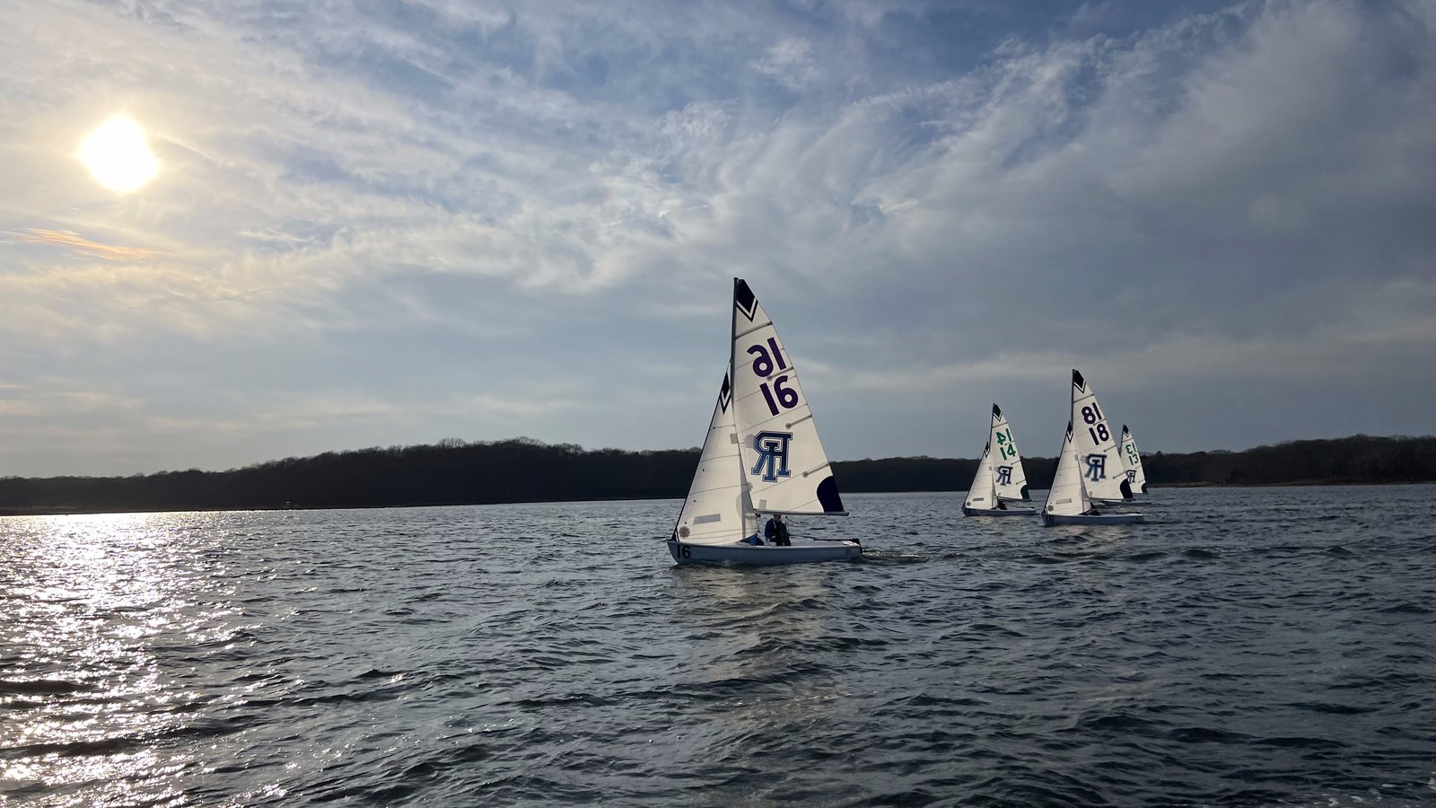 URI sailing team racing at sunset